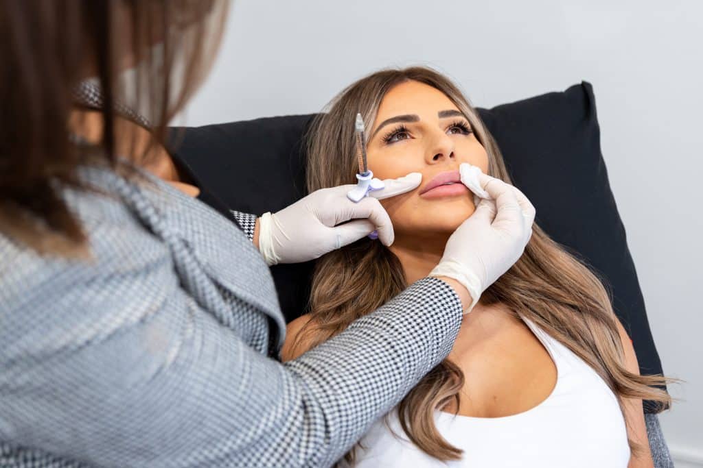 close up of cosmetic nurse biba administering dermal fillers in the form of lip injections to a patient