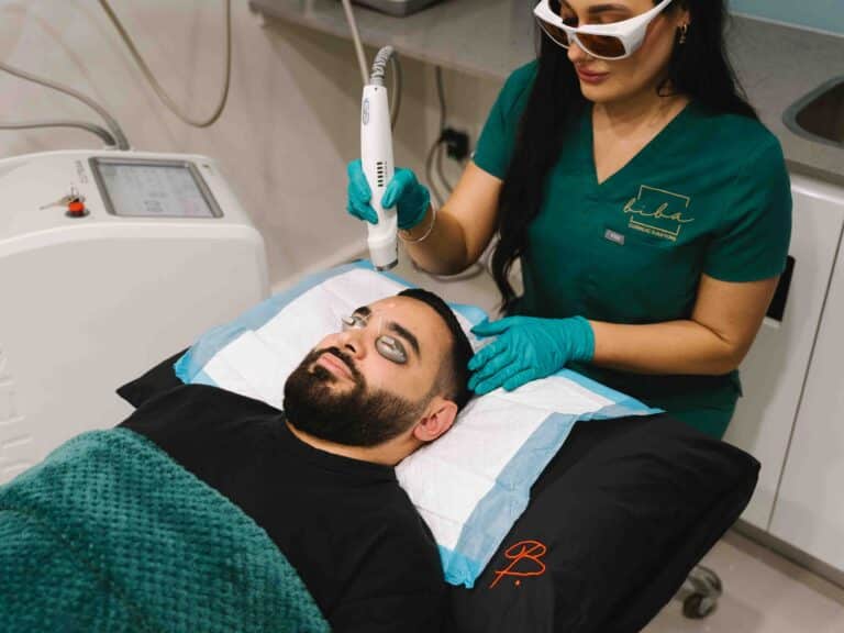 Cosmetic nurse performing skin needling on a male client at a skin care clinic.