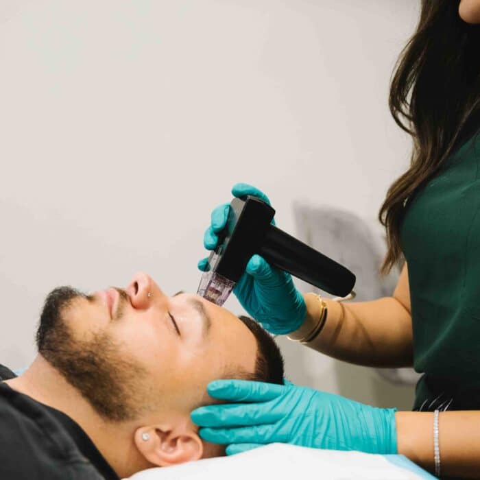 Male client receiving hydrafacial treatment at a cosmetic clinic Parramatta for skin rejuvenation.