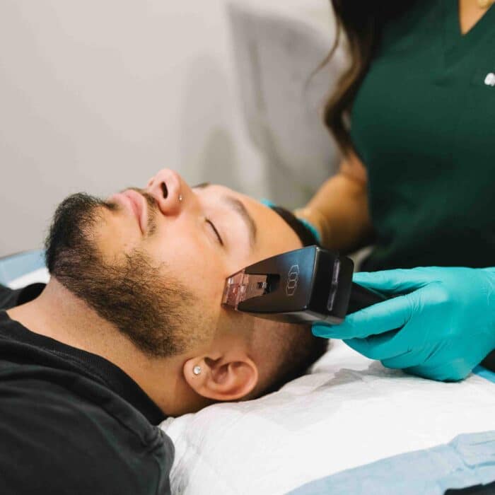 Client receiving a facial skin treatment from a trained practitioner at a professional skin care clinic, focused on improving skin tone and texture.