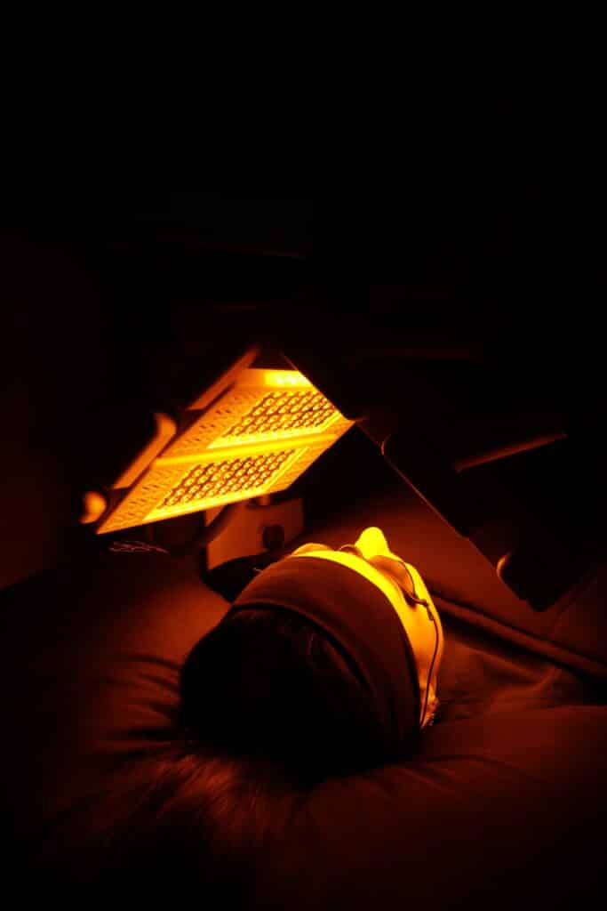 Client undergoing LED light therapy at a skin care clinic, designed to promote collagen production and reduce inflammation.